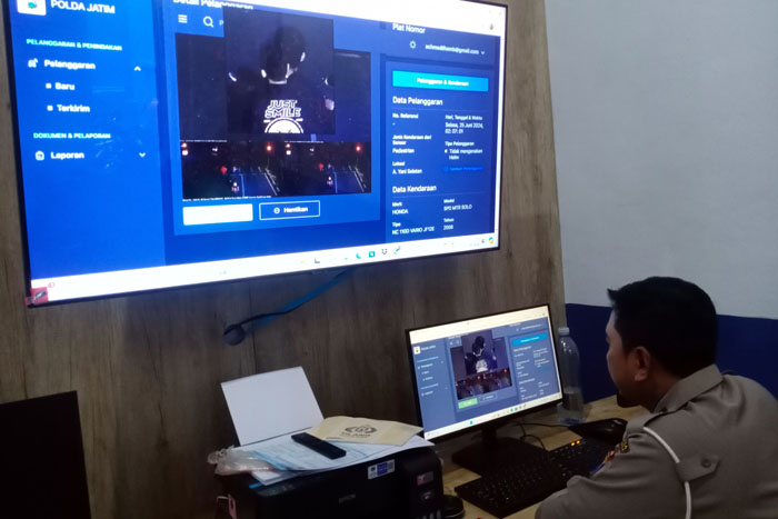 TAK SADAR DITILANG: Petugas back office ETLE statis meneliti ulang gambar pengendara motor yang terekam kamera tidak mengenakan helm di Jalan Ahmad Yani kemarin.