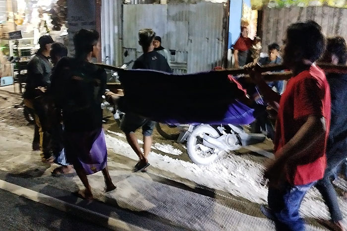 Warga menggotong salah seorang korban kecelakaan di jalan provinsi Desa Amadanom, Kecamatan Dampit, menggunakan kain sarung dan bambu