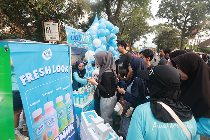 KAMPANYE SEHAT: Pengunjung Car Free Day di Jalan Ijen antre mendapatkan susu yang dibagikan Koperasi Agro Niaga (KAN) Jabung, Minggu pagi (30/6).