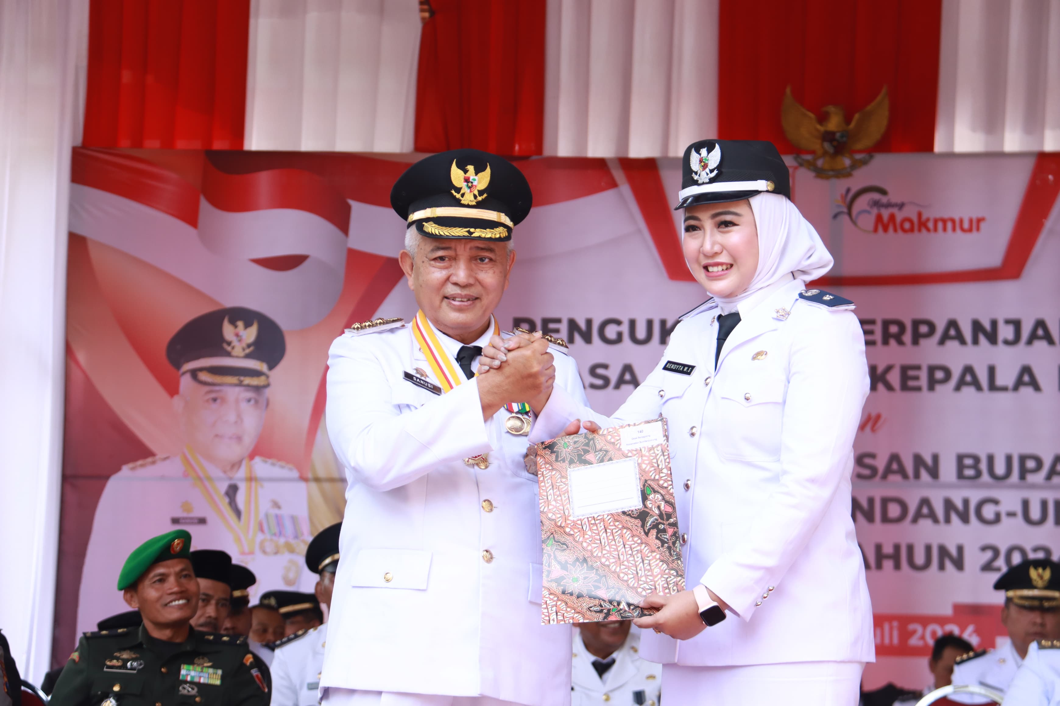 BONUS JABATAN: Bupati Malang H Sanusi (kiri) menyerahkan SK perpanjangan masa jabatan kepada Kades Senggreng Rendyta Witrayani Setyawan di pendapa Pantai Ngliyep kemarin (2/7).
