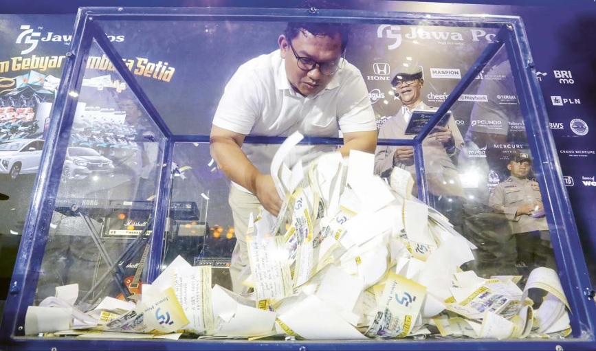 Direktur Jawa Pos Radar Malang Tauhid Wijaya mengundi balot yang dikirim pembaca setia Jawa Pos di gedung Jawa Pos Arena, Surabaya, tadi malam (1/7)