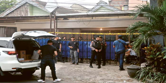 KAGETKAN WARGA: Polisi berjaga dan memasang police line di pagar rumah yang menjadi tempat produksi narkotika di Jalan Bukit Barisan, Kota Malang kemarin