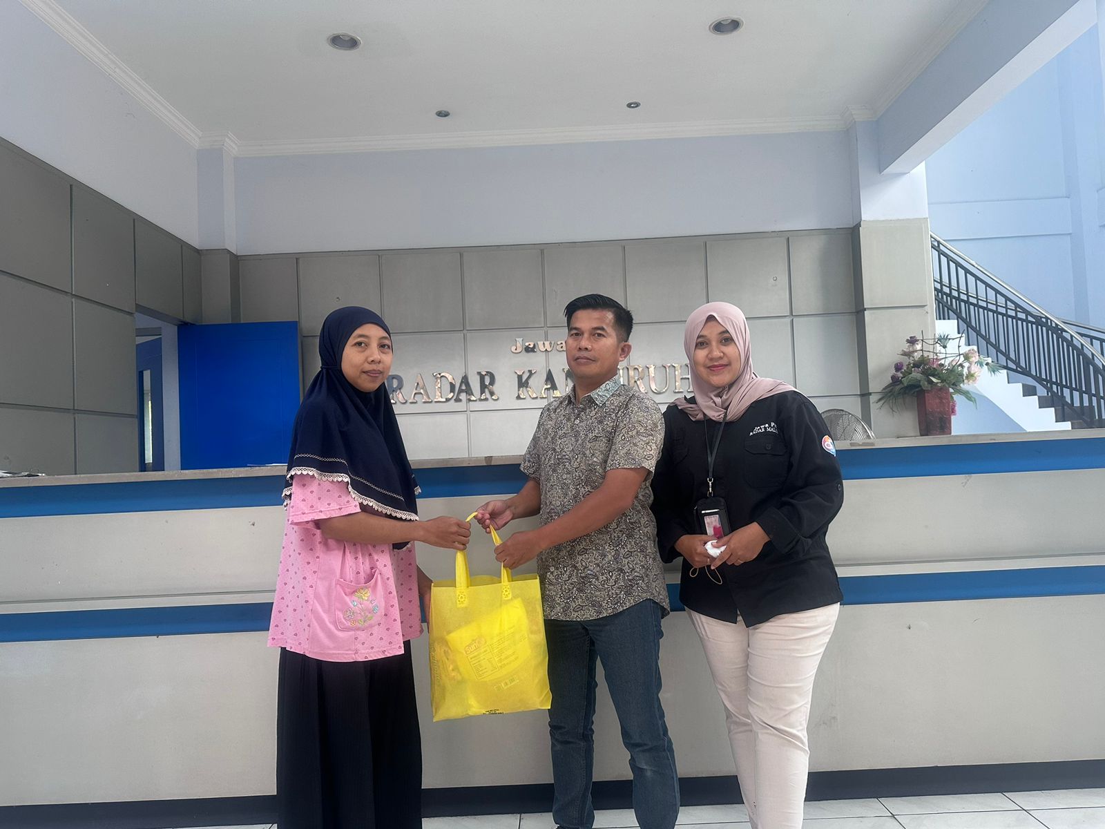 Crew Jawa Pos Radar Kanjuruhan menyerahkan bingkisan sembako kepada salah satu warga