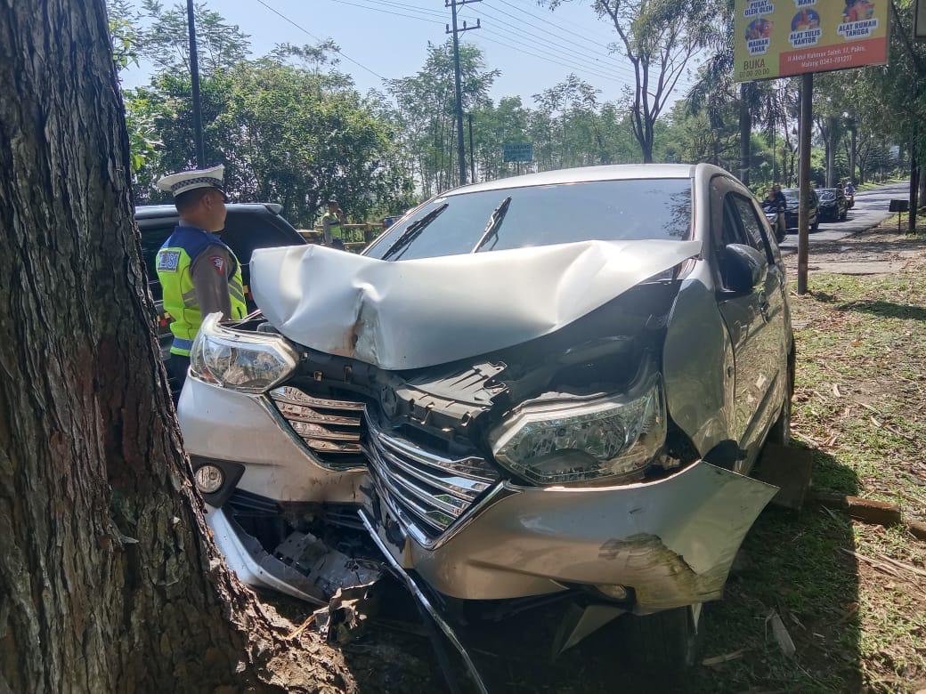 LAKA TUNGGAL: Mobil Toyota Avanza mengalami ringsek di bagian depan setelah menabrak pohon di Jalan Komud Abd Saleh, Desa Asrikaton, Kecamatan Pakis, kemarin (9/7)