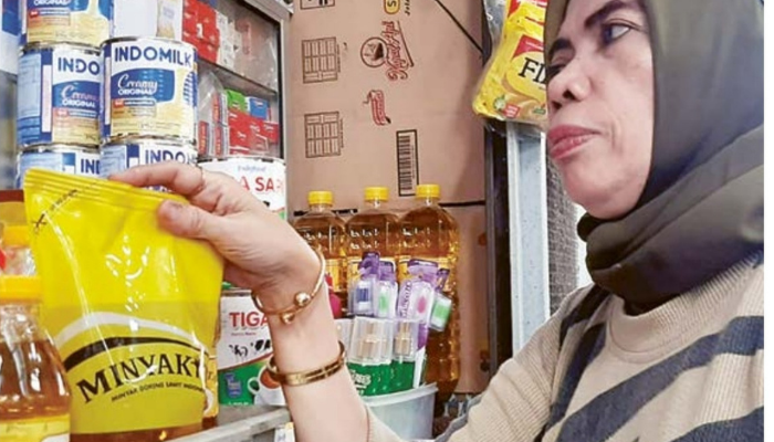 PENJUALAN MENURUN: Pedagang sembako di Pasar Kasin, Rahmawati, menunjukkan stok Minyakita di tokonya kemarin (9/7).