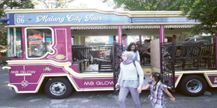 SELALU PENUH: Sejumlah orang tua membawa anaknya berkeliling Kota Malang dengan naik bus Macito kemarin.