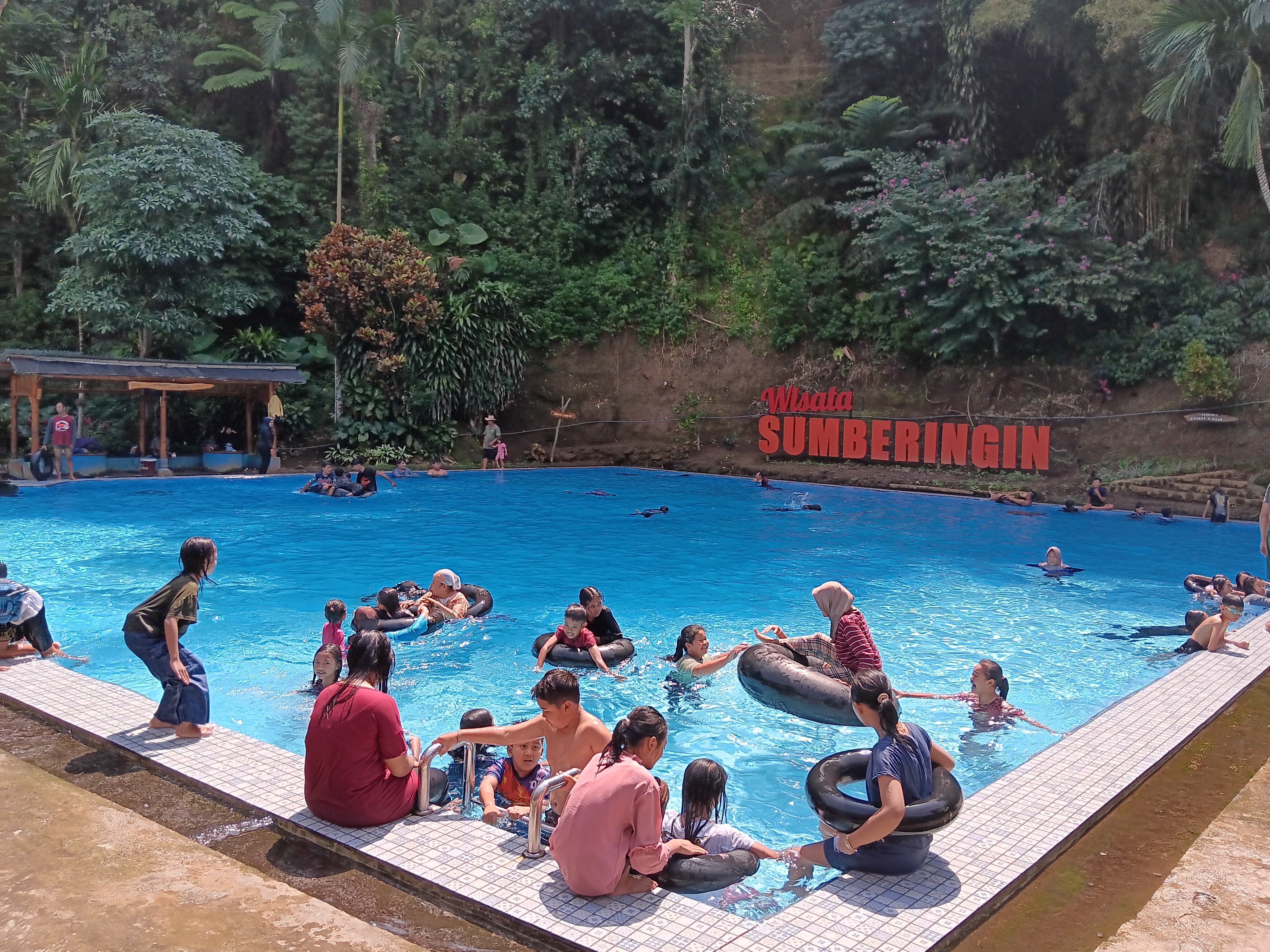 SEJUK: Wisatawan asyik bersantai di kolam renang wisata Sumberingin, Desa Wringinsongo, Kecamatan Tumpang, kemarin (11/7).