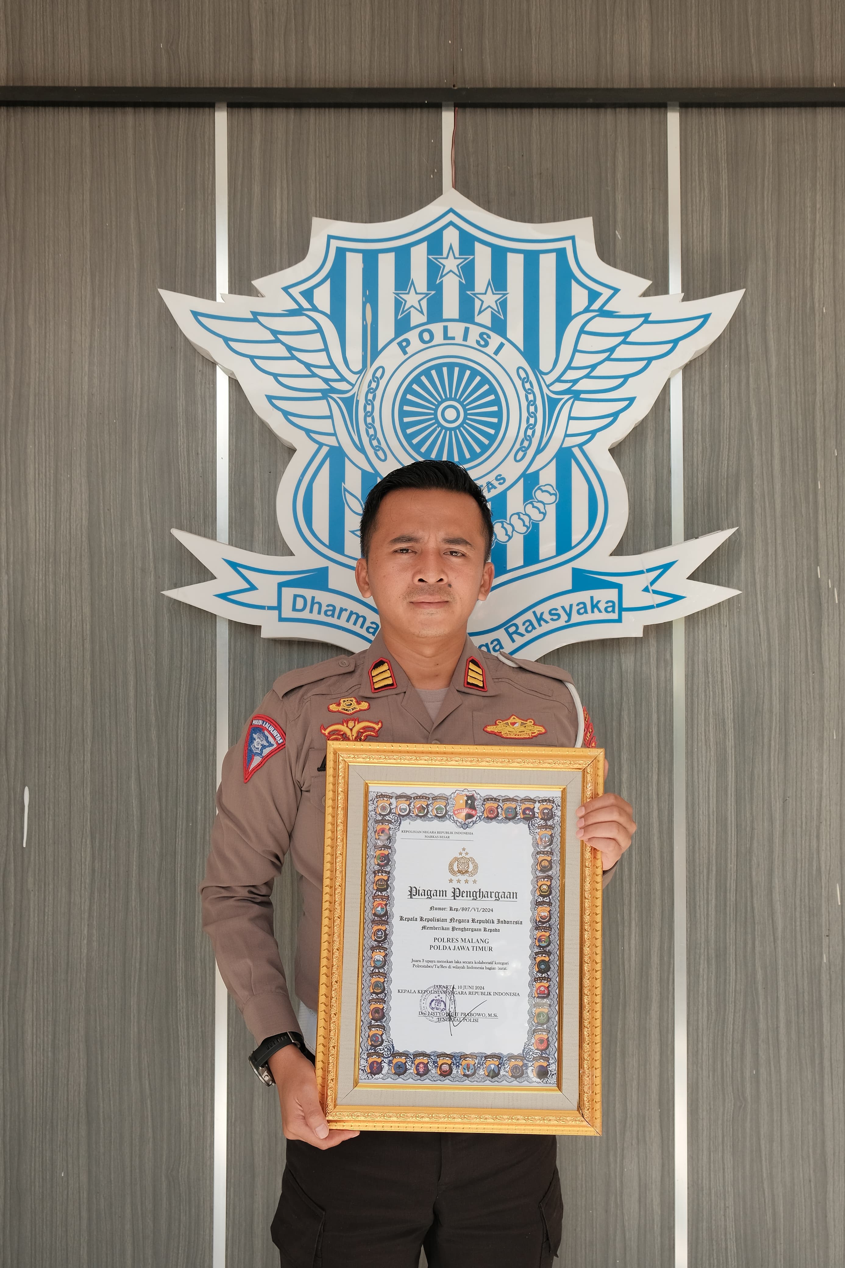 BERPRESTASI: Kasatlantas Polres Malang AKP Adis Dani Garta menunjukkan piagam penghargaan atas keberhasilan menekan angka kecelakaan kemarin.