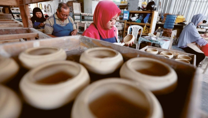 TEKAN HARGA JUAL: Sejumlah pekerja tengah membuat produk keramik di Jalan Tlogo Suryo, Kelurahan Dinoyo, Kecamatan Lowokwaru kemarin (11/7).