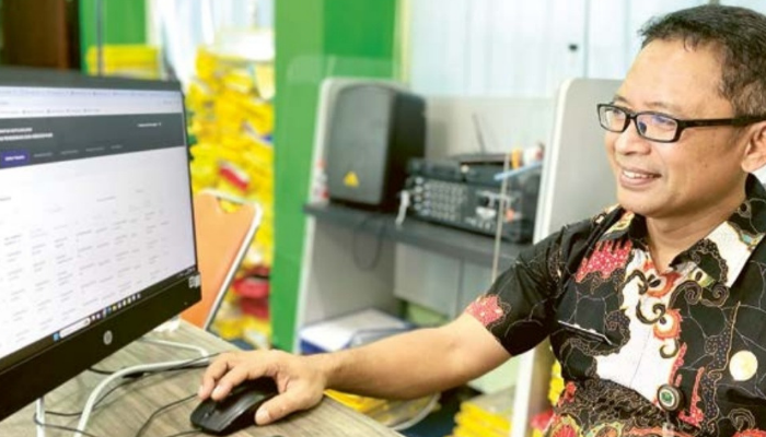 DIUMUMKAN HARI INI: Koordinator Posko PPDB Muflikh Adhim mengecek ulang pendaftar yang sudah melakukan proses verifikasi di Posko PPDB Disdikbud Kota Malang, kemarin (11/7).
