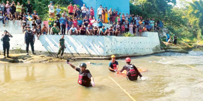 KELUARGA TOLAK OTOPSI: Warga menyaksikan proses evakuasi pemuda yang ditemukan meninggal di sungai Kampung Warna Warni, Jodipan, kemarin.