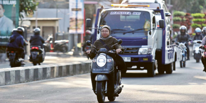 MELANGGAR ATURAN: Pemotor melintas di Jalan Kawi, Kelurahan Bareng, kecamatan Klojen, Kota Malang tanpa mengenakan helm kemarin sore.