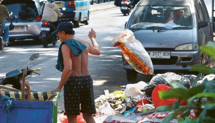 BADAN JALAN MENYEMPIT: Salah satu warga membuang sampah di Jalan Muharto, Kelurahan Kotalama, Kecamatan Kedungkandang kemarin siang. Lokasi itu semakin dipenuhi dengan tumpukan sampah