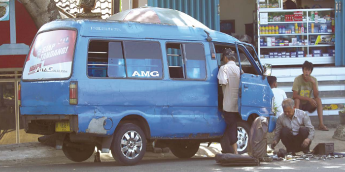 WAKTUNYA GANTI: Sopir angkot trayek Arjosari-Mergosono-Gadang (AMG) melakukan penggantian suku cadang mobil di kawasan Pasar Gadang kemarin siang.