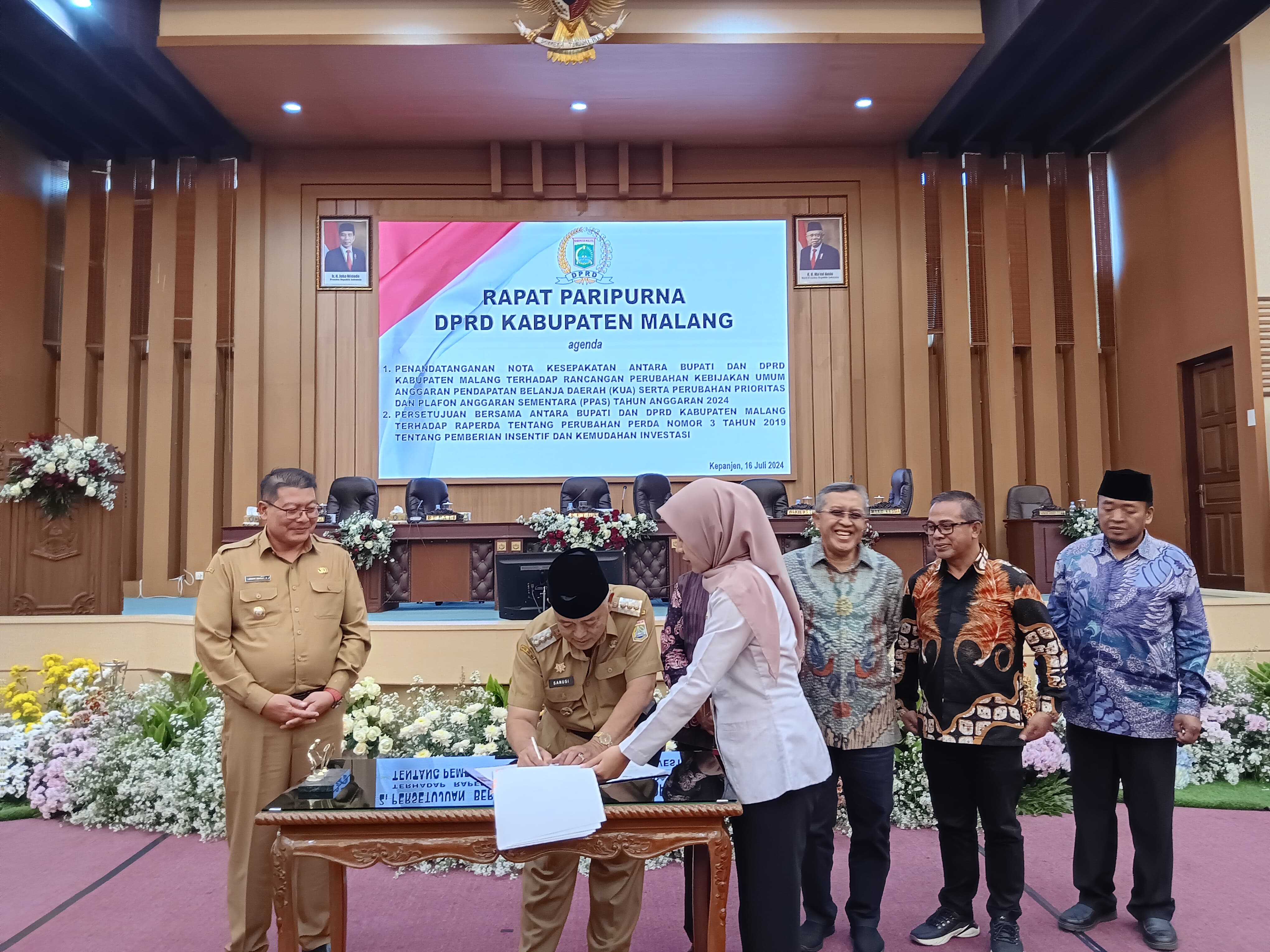 SIMBOLIS: Bupati Malang H M. Sanusi menandatangani dokumen setelah disahkan dalam rapat paripurna kemarin (16/7).