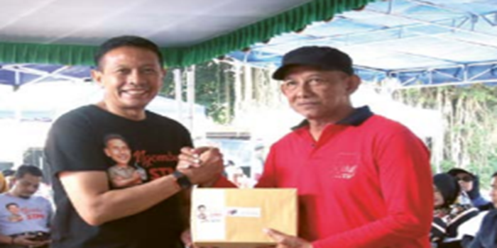 APRESIASI: Pj Wali Kota Malang Wahyu Hidayat (kiri) menyerahkan bantuan secara simbolis kepada warga dalam acara Ngombe.