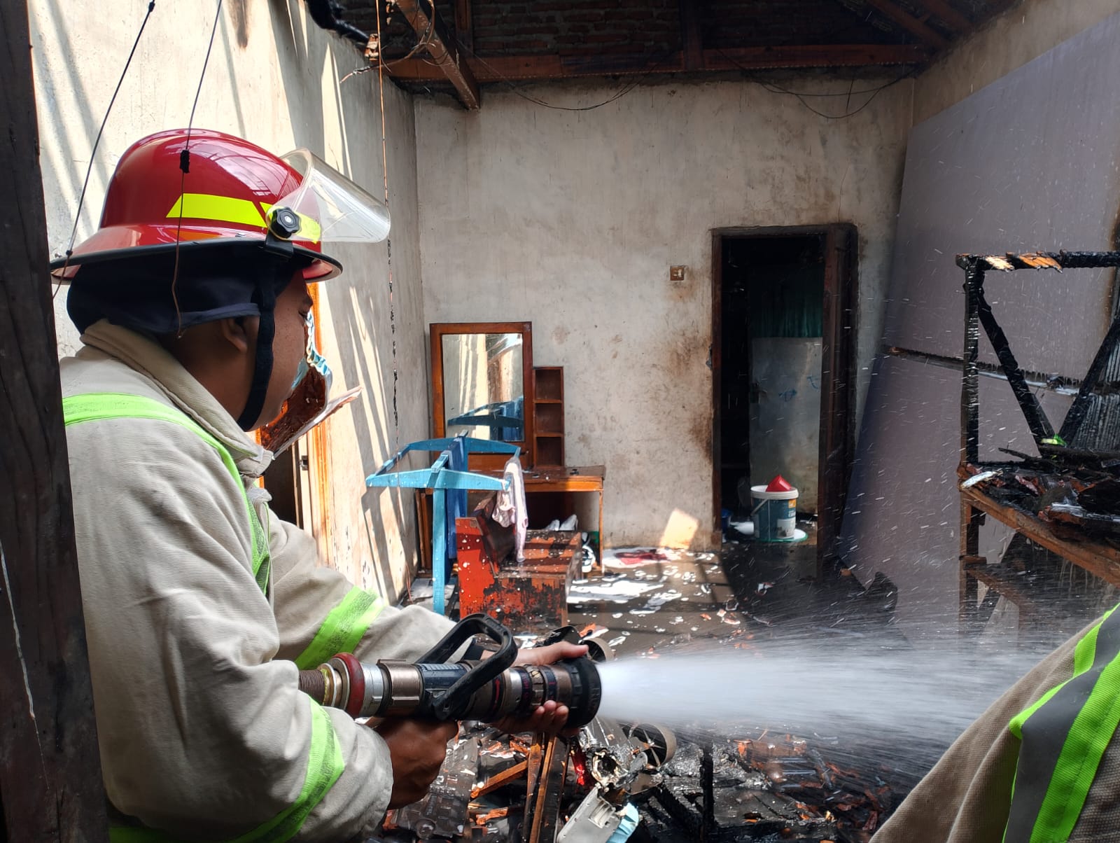 GERAK CEPAT: Petugas Damkar Kabupaten Malang menyemprotkan air ke lokasi titik api kemarin (22/7). Kobaran api berhasil dipadamkan.