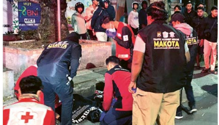 TITIK RAWAN LAKA: Relawan dan tim medis mengevakuasi jenazah Muhammad Zeva Atallah Wicaksana yang mengalami kecelakaan dan meninggal di Jalan Veteran, Kota Malang, kemarin (21/7).