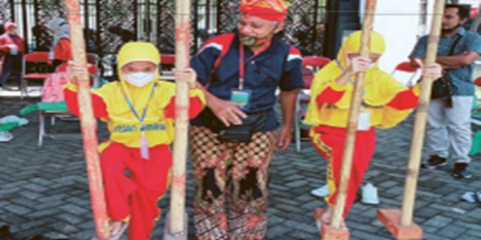 LESTARIKAN BUDAYA: Nanang Kustanto, Ketua Pokdarwis Satria Turangga Jati mengajari siswa PAUD bermain egrang di Kantor Disdikbud Kota Malang, beberapa waktu lalu.