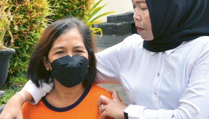 TERSANGKA: Evi Wijayanti digiring menuju tempat pers rilis di Mapolres Malang kemarin (22/7).