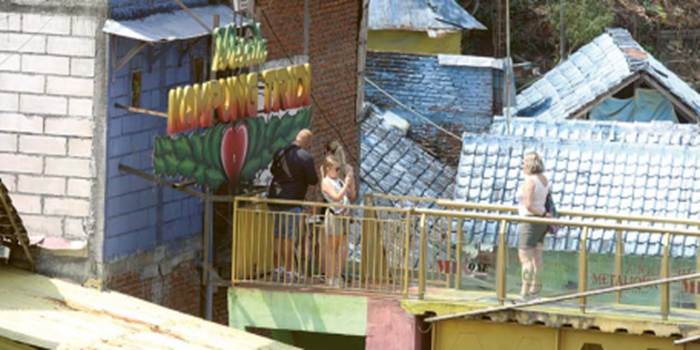 DESTINASI FAVORIT: Sejumlah wisatawan mancanegara foto di ikon Kampung Tridi kemarin. Pemkot Malang berencana menyusun perwali terkait perbaikan kampung tematik menggunakan APBD.