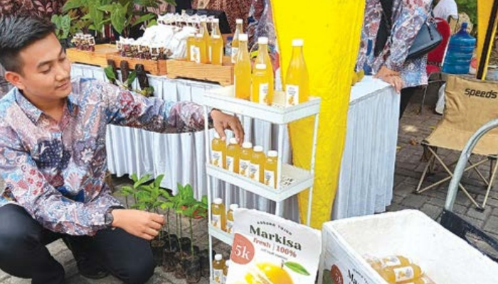 PRODUK LOKAL: Afif Ilham Hamdani, warga Sidorahayu, Wagir yang memasok minuman kemasan merkisa ke luar pulau. Selasa lalu (23/7) dia mengikuti pameran UMKM di Pendapa Paji Kabupaten Malang.