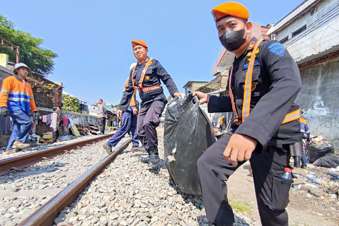 Polsuska mengangkut barang-barang dari bedak liar yang dibongkar di sekitar rel kereta jalur Stasiun Malang-Blimbing