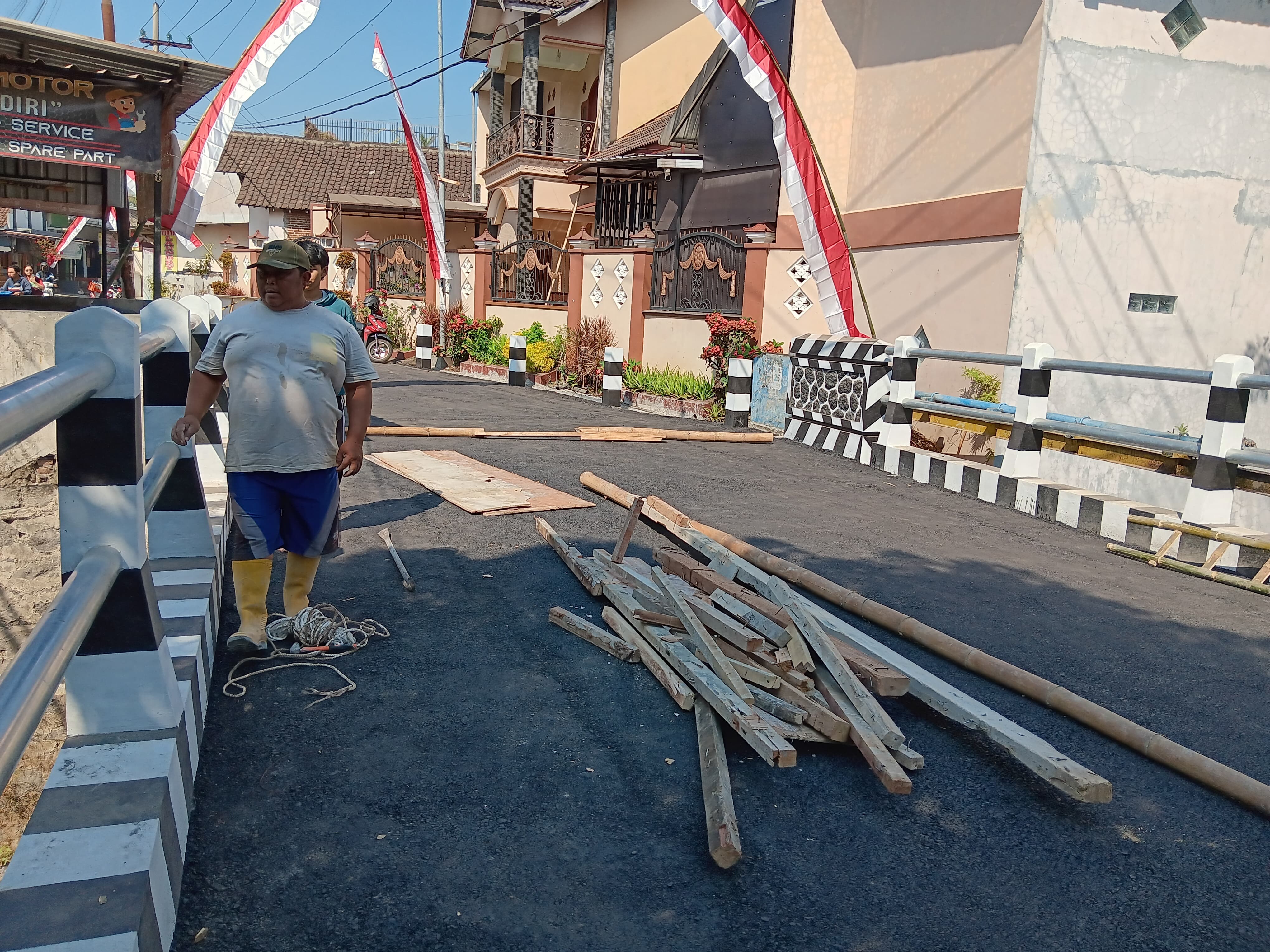 PENGERJAAN TUNTAS: Seorang pekerja melepas kayu pencetak beton di area Jembatan Tirtotaruno, Desa Landungsari, Kecamatan Dau kemarin (25/7).