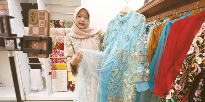 BAWA NAMA MALANG: Salah satu staf di Livyla Collection tengah live di media sosial untuk menunjukkan beberapa produk, kemarin.