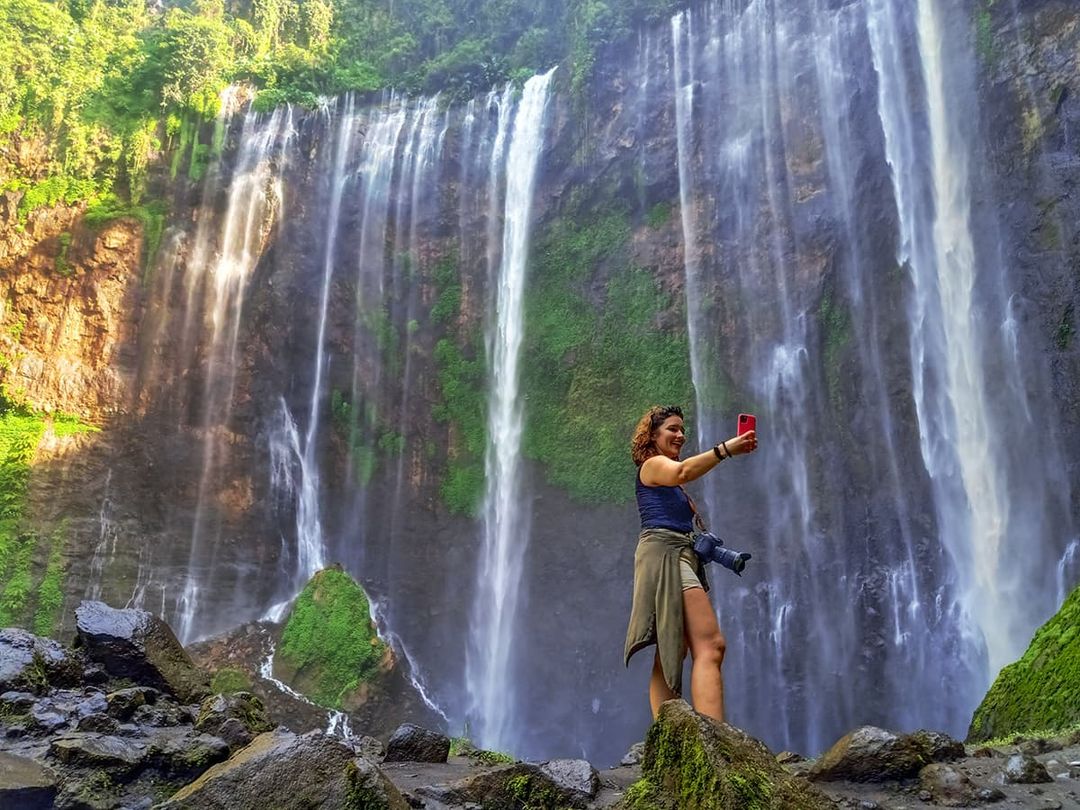 MENYEGARKAN: Seorang wisatawan asing menikmati kesejukan Coban Sewu di Desa Sidorenggo, Kecamatan Ampelgading