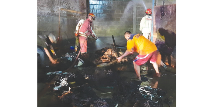 DIPICU PUTUNG ROKOK: Personel Damkar Kabupaten Malang memadamkan api yang membakar karung di area gudang tembakau Desa Kebonagung, Kecamatan Pakisaji kemarin (28/7).