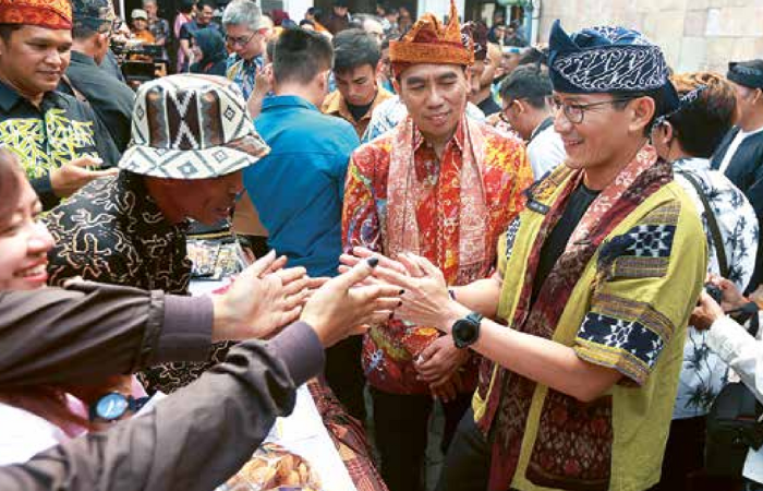 KUNJUNGAN LAPANGAN: Menparekraf Sandiaga Salahuddin Uno berbincang dengan peserta pameran produk unggulan 10 desa wisata terbaik di Jawa Timur di Kampung Kajoetangan Heritage kemarin (28/7).