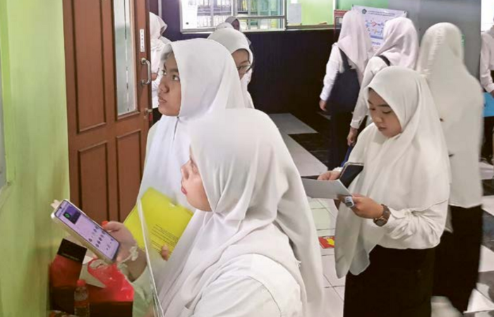 DEG-DEGAN: Sejumlah calon mahasiswa  baru UIN Maliki Malang melihat papan pengumuman tes di ruang ujian.