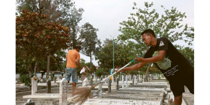 DAPAT PERHATIAN: Dua petugas merawat makam-makam di TMP Untung Suropati, kemarin.