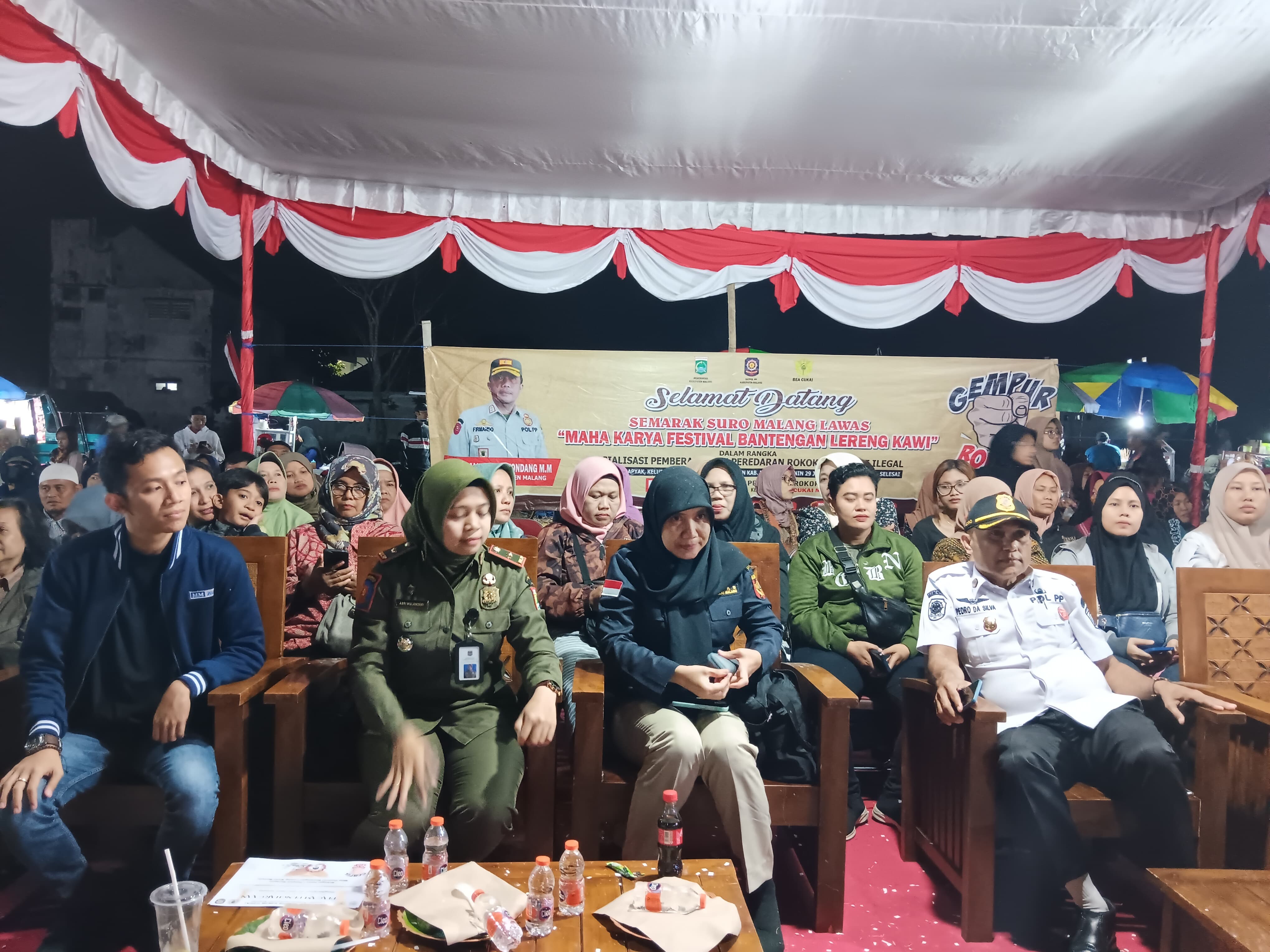 LIBATKAN SENIMAN: Aparat dari Satpol PP Kabupaten Malang, Bea Cukai Malang, dan Pemdes Cempokomulyo menghadiri sosialisasi gempur rokok ilegal Lapangan Krapyak, Cepokomulyo, Kepanjen, kemarin.