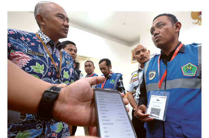 LAYANAN BARU: Sekda Kota Malang Erik Setyo Santoso berbincang dengan juru parkir setelah menyerahkan virtual account dan QR Code kemarin (2/8).