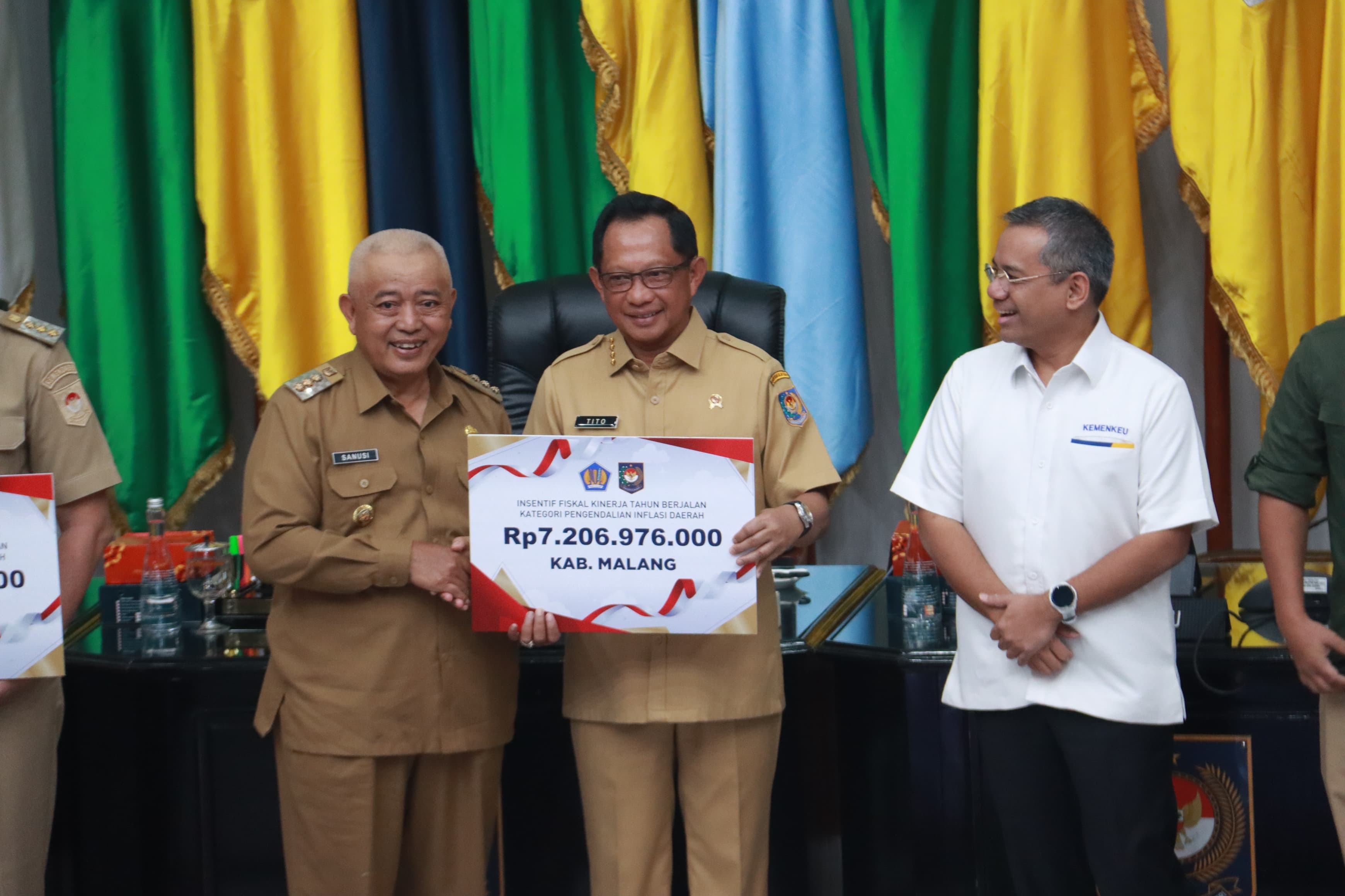 SIMBOLIS: Bupati Malang H M. Sanusi (kiri) menerima insentif Rp 7,20 miliar dari Mendagri Tito Karnavian kemarin.