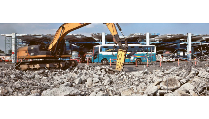 GANTI BARU: Pekerja membongkar sebagian aspal dan beton cor pelataran Terminal Arjosari menggunakan alat berat kemarin (6/8).