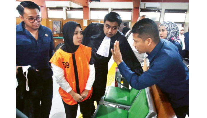 PIKIR-PIKIR: Indah Permatasari berdiskusi dengan kuasa hukumnya setelah mendengarkan putusan yang dibacakan hakim Pengadilan Negeri Malang kemarin (7/8)
