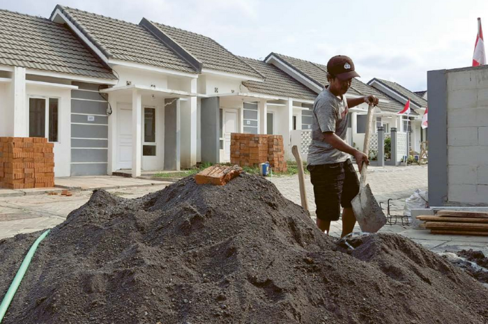 DIKEBUT: Seorang kuli bangunan mengerjakan pembangunan rumah di perumahan ASN Pemkot Malang, Kelurahan Bandulan, Kecamatan Sukun, kemarin.