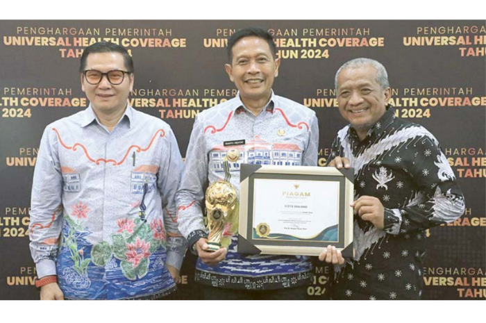 MEMBANGGAKAN: Pj Wali Kota Malang Wahyu Hidayat (tengah) didampingi Kepala Dinkes Kota Malang dr Husnul Muarif (kiri) menerima penghargaan UHC Award 2024 pada Kamis (8/8).