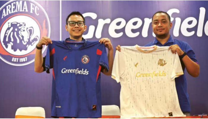 SUNTIKAN DANA:Chief Marketing Officer Greenfields Erwin Cahaya Adi (kiri) dengan Manajer Bisnis Arema FC Munif Bagaskara Wakid menunjukkan jersey tim sebagai simbol kerja sama, kemarin.