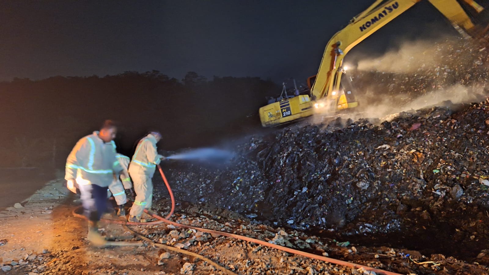 SIGAP: Satu unit ekskavator mengurai tumpukan sampah yang terbakar di TPA Talangagung, Kepanjen, kemarin. Sampah yang terurai lantas disemprot menggunakan air.
