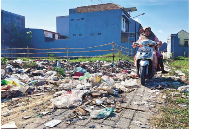 KOTOR: pengendara motor melintas di tembusan Jalan Gadang yang penuh dengan sampah kemarin (19/8). Warga RW 4 Kelurahan Gadang sempat kerja bakti melakukan pembersihan, tapi para pembuangsampah terus