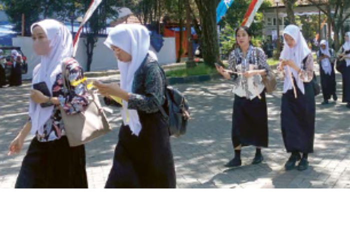 DIBAGI DUA SESI: Mahasiswa baru Universitas Negeri Malang (UM) berjalan menuju gedung Graha Cakrawala, kemarin siang.