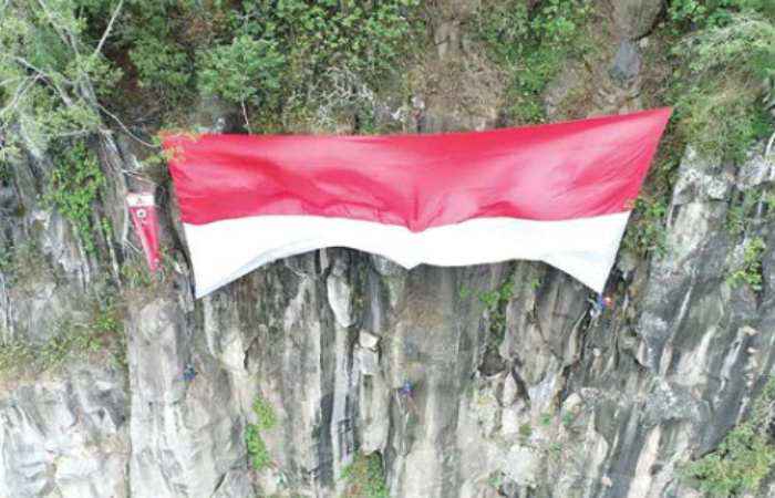 KALI KETIGA: Bendera merah putih raksasa dikibarkan DIMPA UMM di tebing Pujon Hill pada 17 Agustus lalu.
