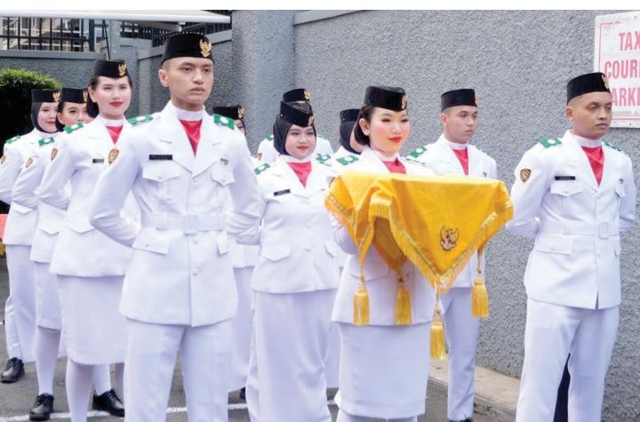 MEMBANGGAKAN: Sabriza (tengah) bertugas menjadi pembawa baki bendera merah putih di halaman KJRI Melbourne, Australia.