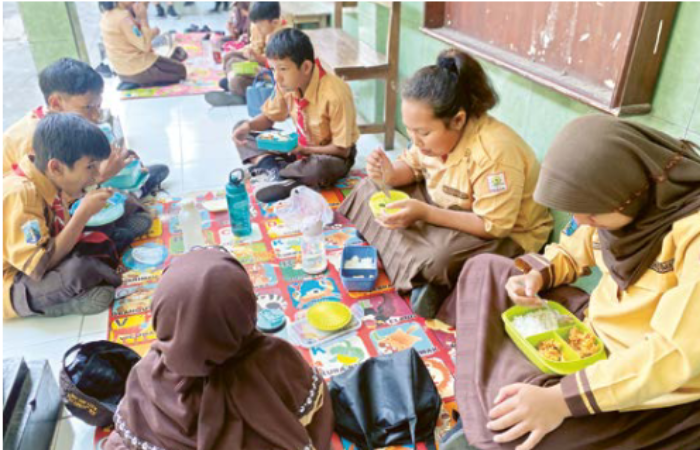 SAMBUT BAIK: Siswa-siswi SD Negeri Jatimulyo 3 makan bekal bersama di depan kelas, Jumat lalu (23/8).