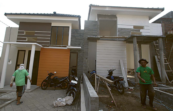 seteNGah Jadi: dua pekerja mengebut pengerjaan rumah subsidi yang berada di daerah Wonokoyo, Kedungkandang, kemarin siang.