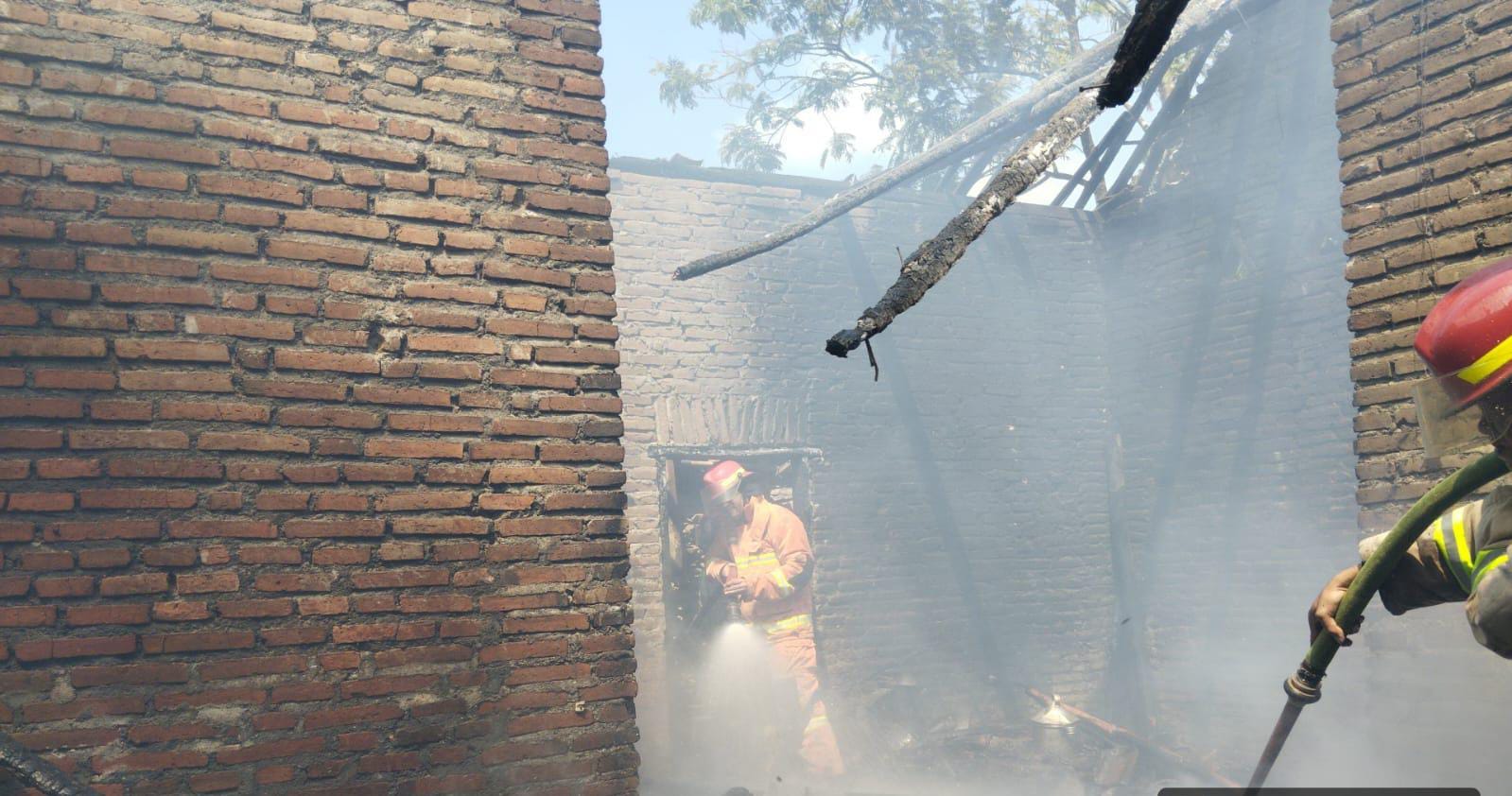 MUSIBAH: Personel Damkar Kabupaten Malang memadamkan kobaran api di rumah warga RT 18 RW 07 Dusun Renteng, Desa Kasri, Kecamatan Bululawang, kemarin.